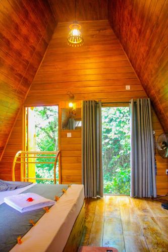 a bedroom with a bed and a large window at Sigiriya Eco Tree House in Sigiriya