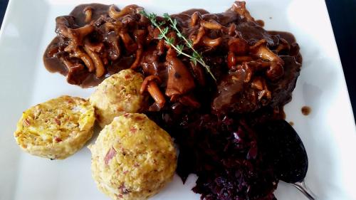 a white plate of food with meat and vegetables at Ferienwohnungen Auhaus in Martello