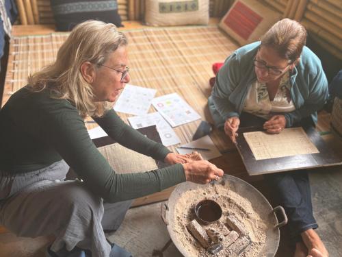 two women sitting at a table working on a wheel at maison Rose & Jardinier eco homestay in Sa Pa