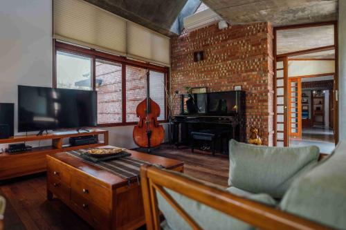a living room with a couch and a television and a guitar at Chang House in Zhuangwei