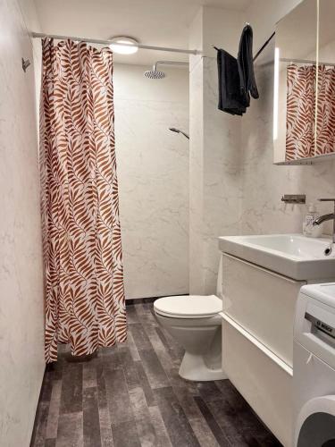a bathroom with a toilet and a shower curtain at Stor lägenhet i centrala Karlshamn! in Karlshamn