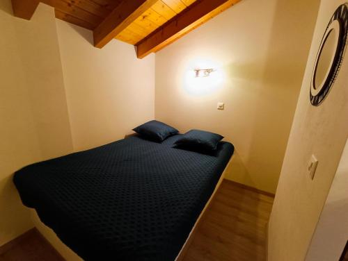 a small bedroom with a black bed in a room at Le Bargeot à Baar in Nendaz