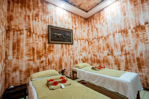 a room with two beds with flowers on them at PrideInn Flamingo Beach Resort & Spa Mombasa in Mombasa