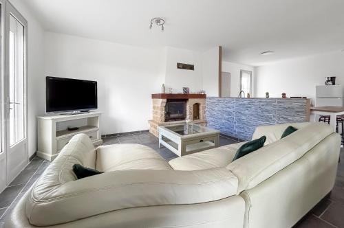 un salon avec un canapé blanc et une cheminée dans l'établissement Le Refuge de Garat Piscine Privée, à Garat