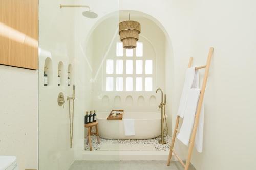 Habitación con ventana y baño con bañera. en The Makara Villas Uluwatu, en Uluwatu