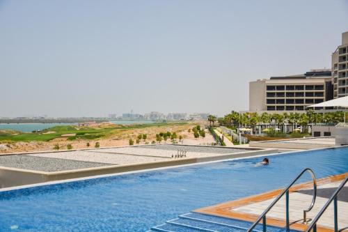 a pool at a resort with people swimming in it at Voyage One Bedroom In Mayan in Abu Dhabi