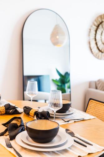 a dining room table with plates and wine glasses at Voyage One Bedroom In Mayan in Abu Dhabi