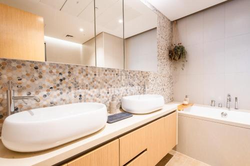 a bathroom with a white sink and a tub at Voyage One Bedroom In Mayan in Abu Dhabi