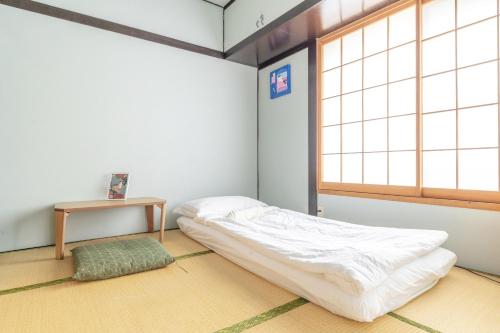 a room with a bed and a table and a window at Jazz Cat- Japanese Style House, 1Min to sta- 5 Lines Access- Direct to Shinjuku & Shibuya&Akihabara in Tokyo