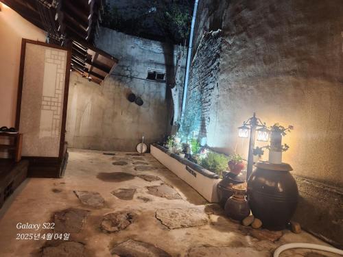 a hallway with a lamp and plants in a building at Hanok1942 in Daegu