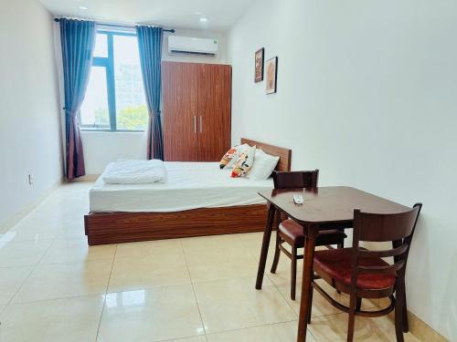 a bedroom with a bed and a desk and a table at Louis Otis Apartment in Da Nang