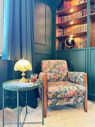 a room with a chair and a table with a lamp at Green Library, appartement 6 personnes à Nemours in Nemours