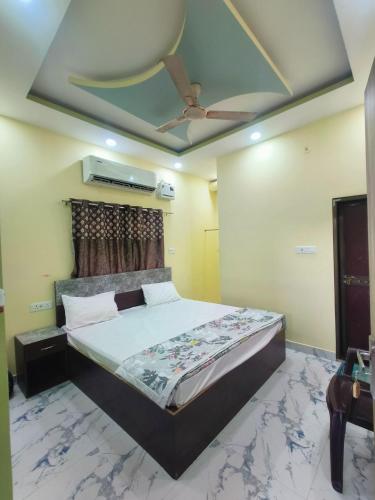um quarto com uma cama e um ventilador de teto em Parth homstay em Ayodhya