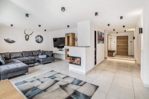 a living room with a couch and a fireplace at Stylish Alpine Apartment with Terrace, Fireplace & Mountain View near Sterzing - Villa Tribulaunblick in Colle Isarco