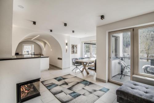 an open living room with a fireplace and a dining room at Stylish Alpine Apartment with Terrace, Fireplace & Mountain View near Sterzing - Villa Tribulaunblick in Colle Isarco