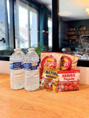 two bottles of water and two bags of food on a table at Green Library, appartement 6 personnes à Nemours in Nemours