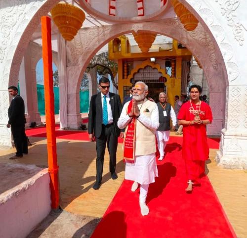 a man is walking on a red carpet at Karma Hostel in Khajurāho