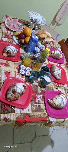a table with plates of bread and fruit on it at Casa Holiday Sea Etna Di Enza in Linguaglossa