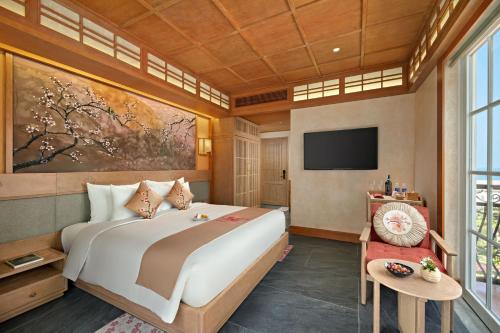 a bedroom with a large bed and a flat screen tv at Sakurakyo Hotel & Spa Phu Quoc - Free Hon Thom Island Waterpark Cable Car Until 15 December 2025 in Phu Quoc