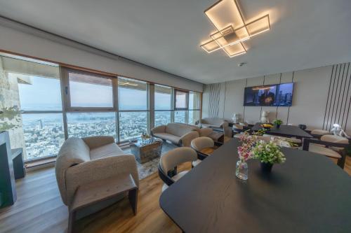 a living room with a table and chairs and windows at Crowne Plaza Haifa by IHG in Haifa