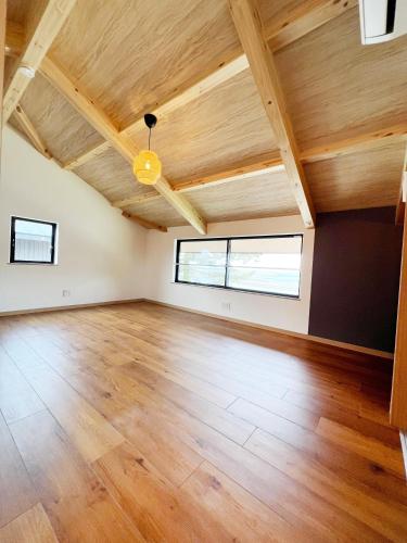 an empty room with wooden ceilings and wood floors at Rainbow Village（レインボーヴィレッジ） in Mihama