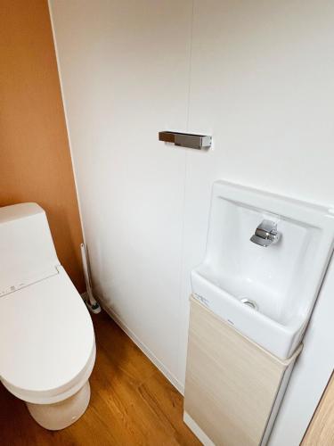 a bathroom with a white toilet and a sink at Rainbow Village（レインボーヴィレッジ） in Mihama