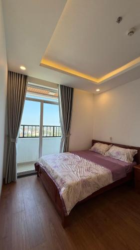 a bedroom with a large bed and a large window at Gạo 88 House in Thôn Dương Phẩm