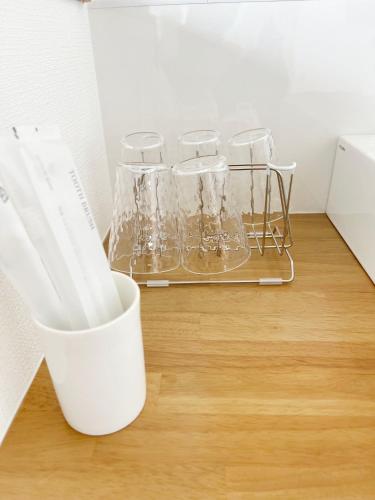 a rack of glasses sitting on a wooden floor at Rainbow Village（レインボーヴィレッジ） in Mihama