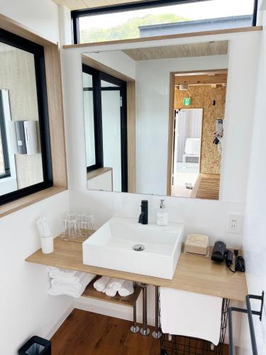 a bathroom with a white sink and a mirror at Rainbow Village（レインボーヴィレッジ） in Mihama