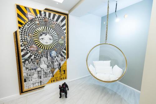 a mirror and a chair in a room with a painting at COLLINE Rezidențial in Rediu