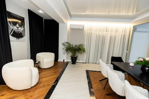 a living room with a table and white chairs at COLLINE Rezidențial in Rediu