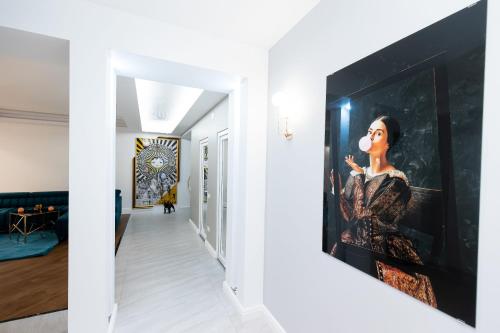 a hallway with a painting of a woman on a wall at COLLINE Rezidențial in Rediu