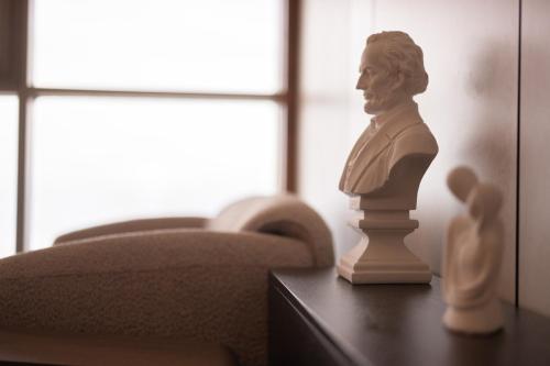 a statue of a man on a table next to a couch at Crowne Plaza Haifa by IHG in Haifa