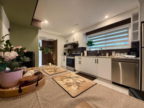 a kitchen with a table and a sink and a counter at Brand New 2 Bedroom Suite in Langley Twp - Play Area, Patio & Mini Golf in Aldergrove