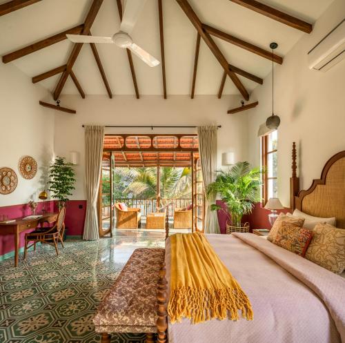 a bedroom with a large bed and a table at Villa Fado - 4BHK Luxury Villa with Big Private Pool, Kitchen, Balcony, Patio, Caretaker, Power Backup, Security & WiFi located closer to Vagator Beach in Assagao
