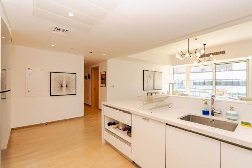 a white kitchen with a sink and a counter at Voyage 2 Bedroom In Mayan With Beach Access in Abu Dhabi