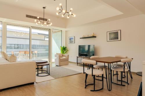a dining room and living room with a table and chairs at Voyage 2 Bedroom In Mayan With Beach Access in Abu Dhabi