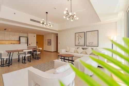 a living room with white furniture and a kitchen at Voyage 2 Bedroom In Mayan With Beach Access in Abu Dhabi