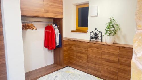a walk in closet with wood paneling and a window at Villa Beelvita&Jacuzzi in Bielovce