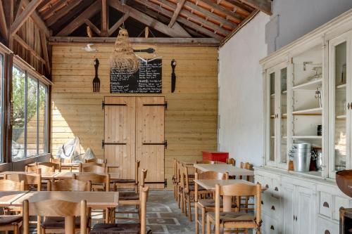 a dining room with wooden tables and chairs at Gite de l'école des Gourmands in Moulin-Neuf