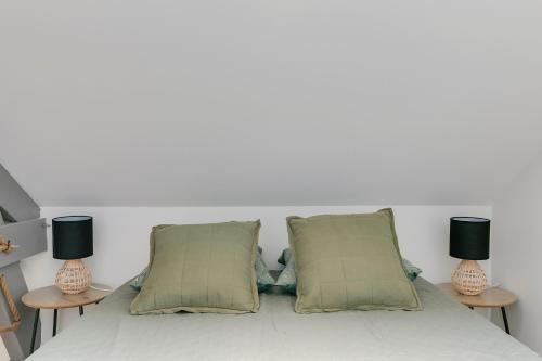 a white bed with two lamps on two tables at Gite de l'école des Gourmands in Moulin-Neuf