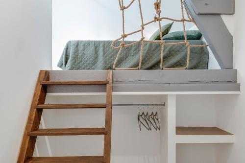 a loft bed in a room with a ladder at Gite de l'école des Gourmands in Moulin-Neuf