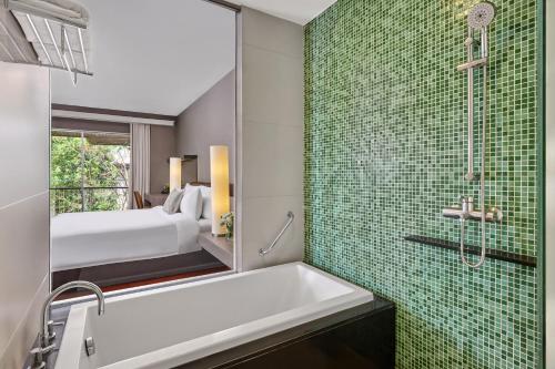 a bathroom with a tub and a shower and a bed at The Park Nine Hotel Srinakarin in Bangkok