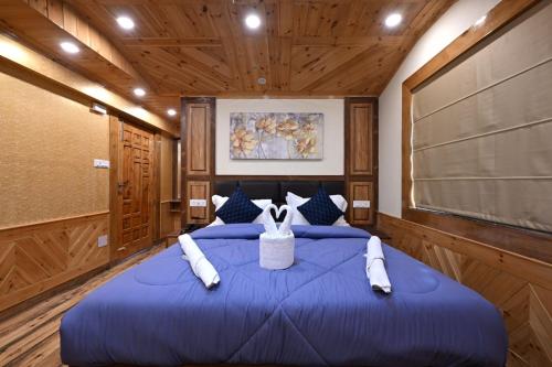 a large blue bed in a room with wooden walls at 2 bedrooms Sun Rise Pvt balcoy by Humble Stay in Cheog
