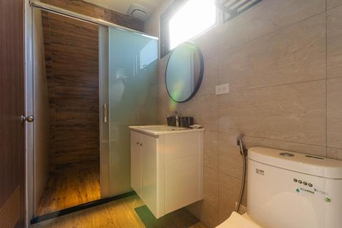 a bathroom with a toilet and a mirror on the wall at 微風星語名宿WindStar B&B in Jian
