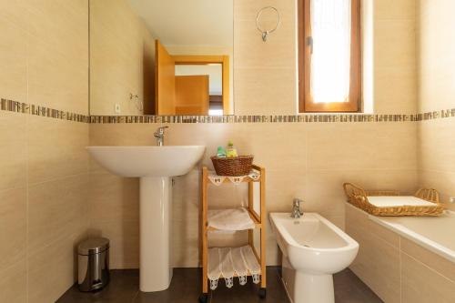 a bathroom with a sink and a toilet and a mirror at La Pergola in Santillana del Mar