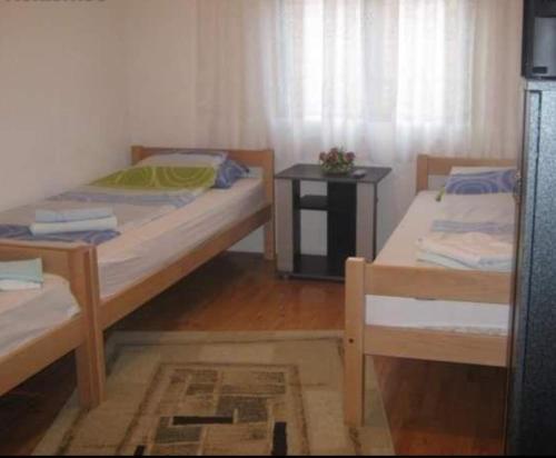 奥赫里德Guest house Kiko的小型客房配有两张床、一张桌子和一张床。