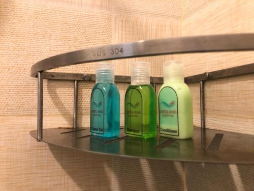 three bottles of soap on a shelf in a bathroom at Capital Wind Beach Cabanas in Kalpitiya