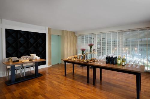 a dining room with a table with wine glasses at The Park Nine Hotel Srinakarin in Bangkok