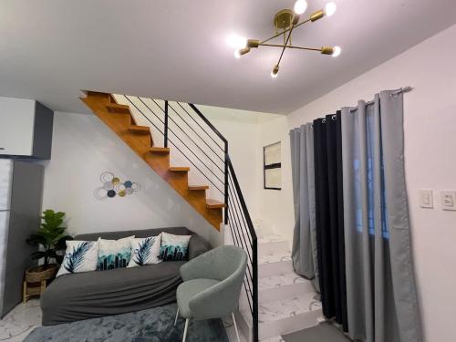 a living room with a couch and a staircase at Homefortzone near D' outlet lima in Sampong